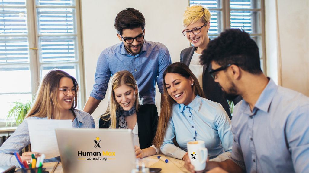 Equipo de trabajo feliz, clave del éxito empresarial – Human Max Colaboradores sonrientes trabajando juntos en oficina, promoviendo la felicidad laboral – Human Max